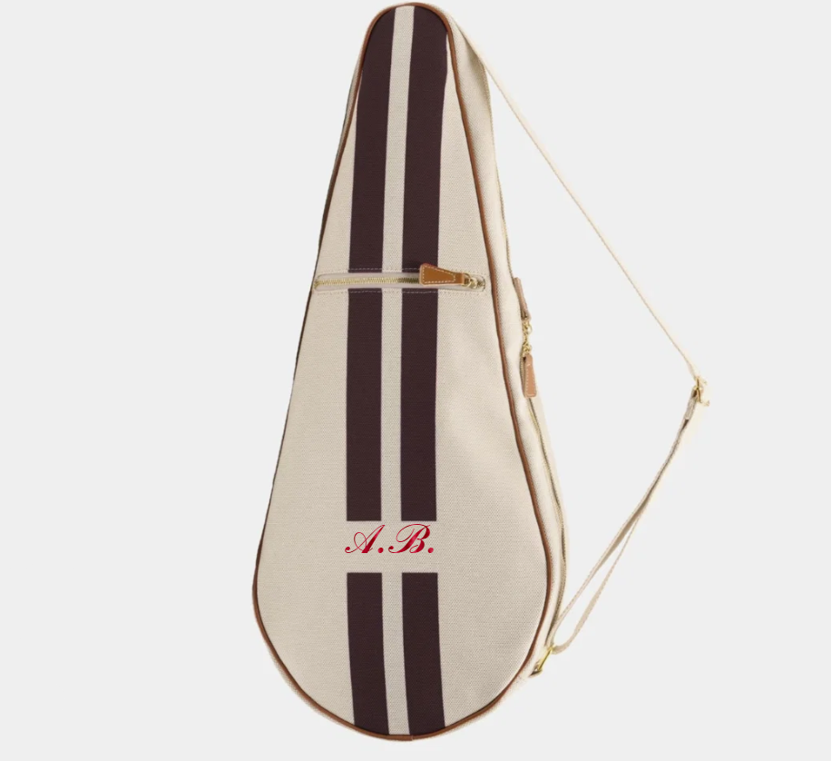 A cream-colored canvas instrument case with two dark brown vertical stripes, featuring red cursive initials 'A.B.