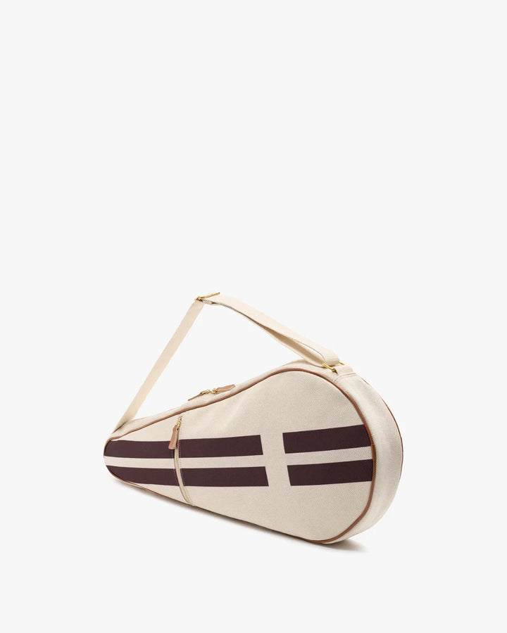 A cream-colored tennis racket case with dark brown stripes and a white cross design, featuring a matching shoulder strap and gold-tone hardware, set against a plain white background.